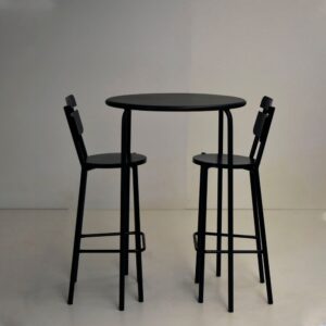 Barra alta redonda negra modelo París con dos banquetas de caño a juego modelo Indias sobre un fondo claro.