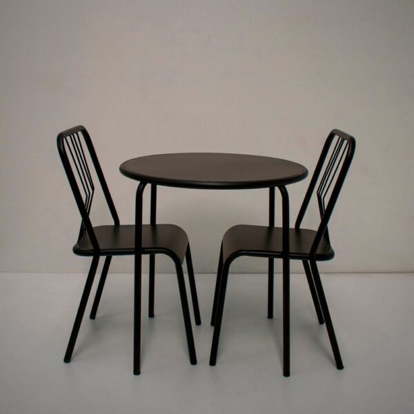 Mesa redonda negra y dos sillas de caño a juego, modelo París, con respaldo de varillas y estilo industrial.