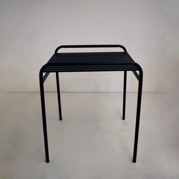 Mesa 3010 de caño estructural en color negro con tapa de varillas metálicas, sobre un fondo liso y claro.