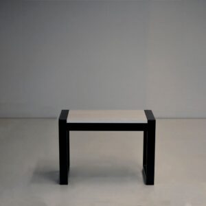 Mesa ratona modelo Lena con estructura de caño negro y tapa rectangular de madera clara, sobre un fondo gris neutro.