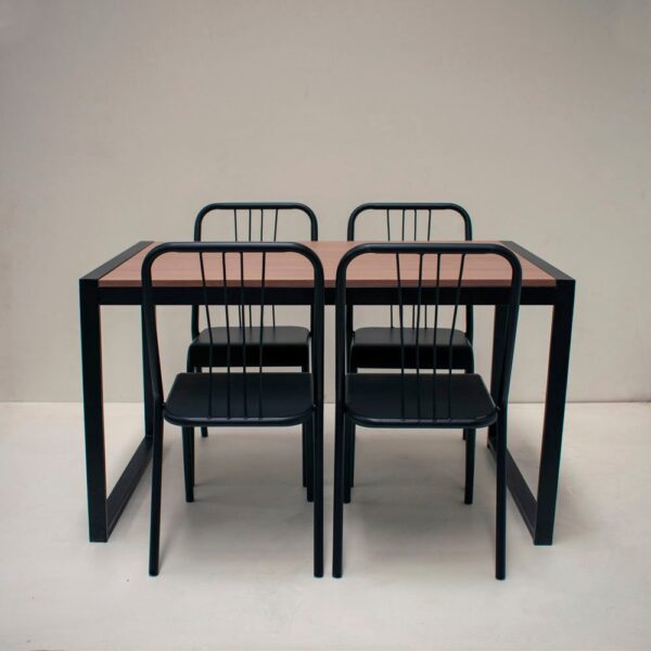 Mesa de comedor rectangular con tapa símil madera y estructura negra, con cuatro sillas de metal negro a juego.